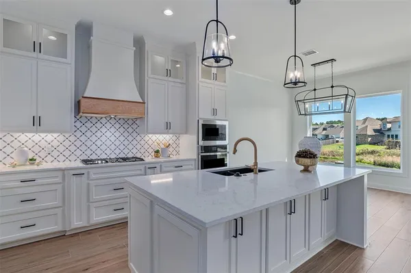 a kitchen with stainless steel appliances a stove a sink and a refrigerator