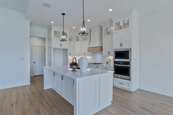 a kitchen with kitchen island a stove a sink and a wooden floor