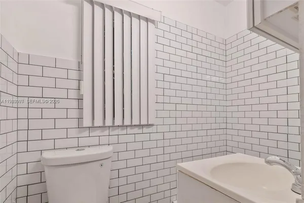 a bathroom with a sink a toilet and mirror