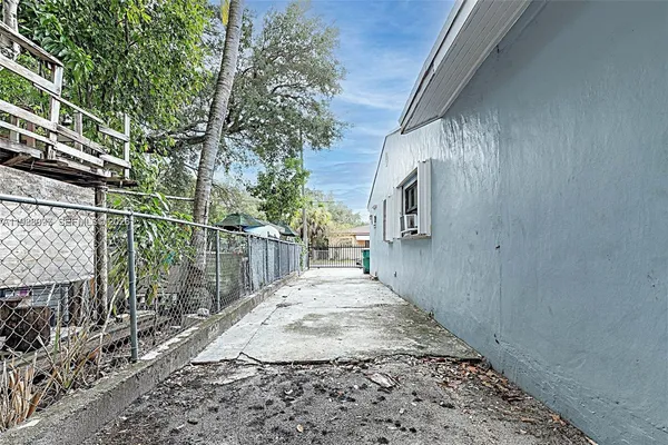 a view of a pathway of a house with a wooden fence