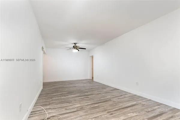 a view of empty room with wooden floor