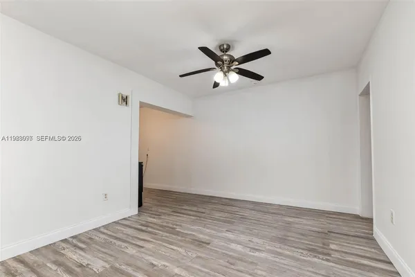 a view of a big room with wooden floor and a ceiling fan