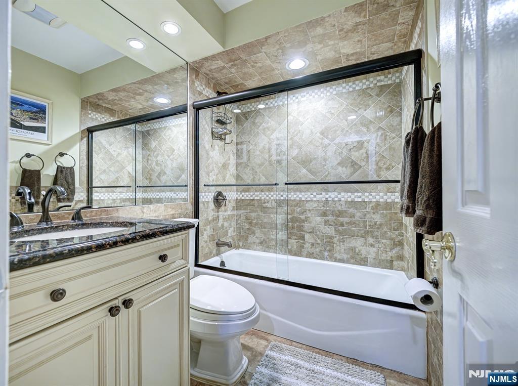 59 David Road Cedar Grove, NJ 07009 - Photo 12 of 24 a bathroom with a granite countertop sink mirror vanity and toilet