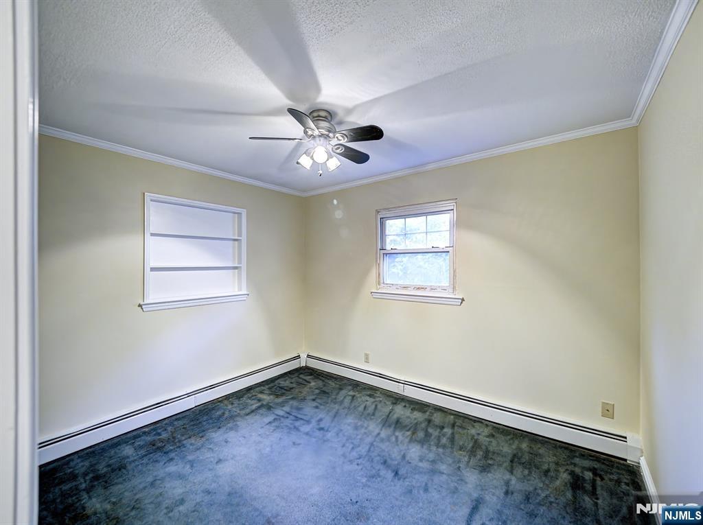 59 David Road Cedar Grove, NJ 07009 - Photo 13 of 24 an empty room with a window and a ceiling fan