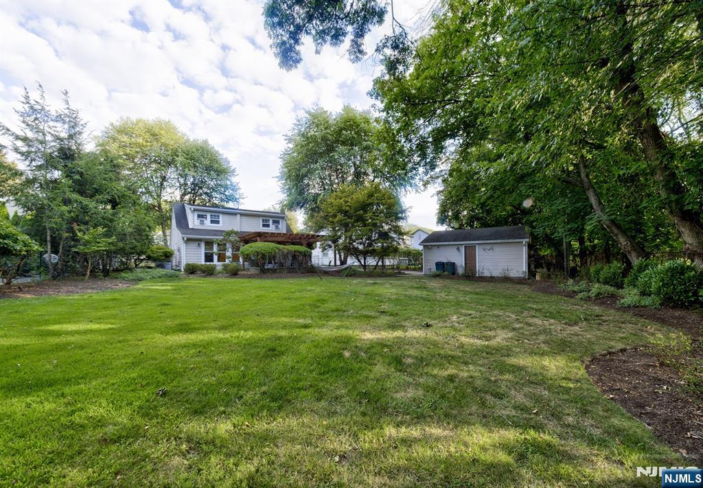 59 David Road Cedar Grove, NJ 07009 - Photo 22 of 24 a view of a big yard with potted plants and large trees