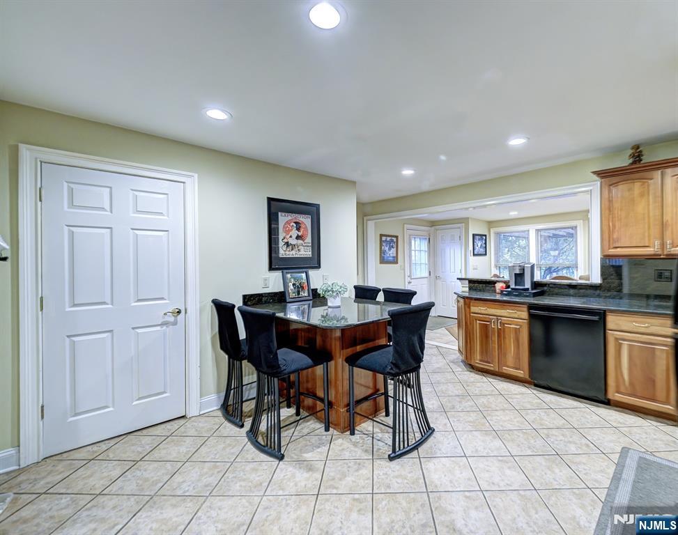 59 David Road Cedar Grove, NJ 07009 - Photo 4 of 24 a open kitchen with stainless steel appliances granite countertop a sink a stove a dining table and chairs