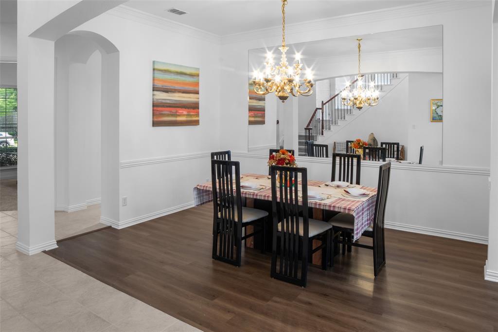 1818 Port Isabel Drive Allen, TX 75013 - Photo 12 of 38 a view of a dining room with furniture a chandelier and wooden floor