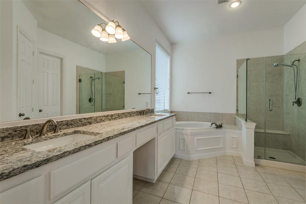 1818 Port Isabel Drive Allen, TX 75013 - Photo 17 of 38 a bathroom with a granite countertop sink a toilet a mirror and shower