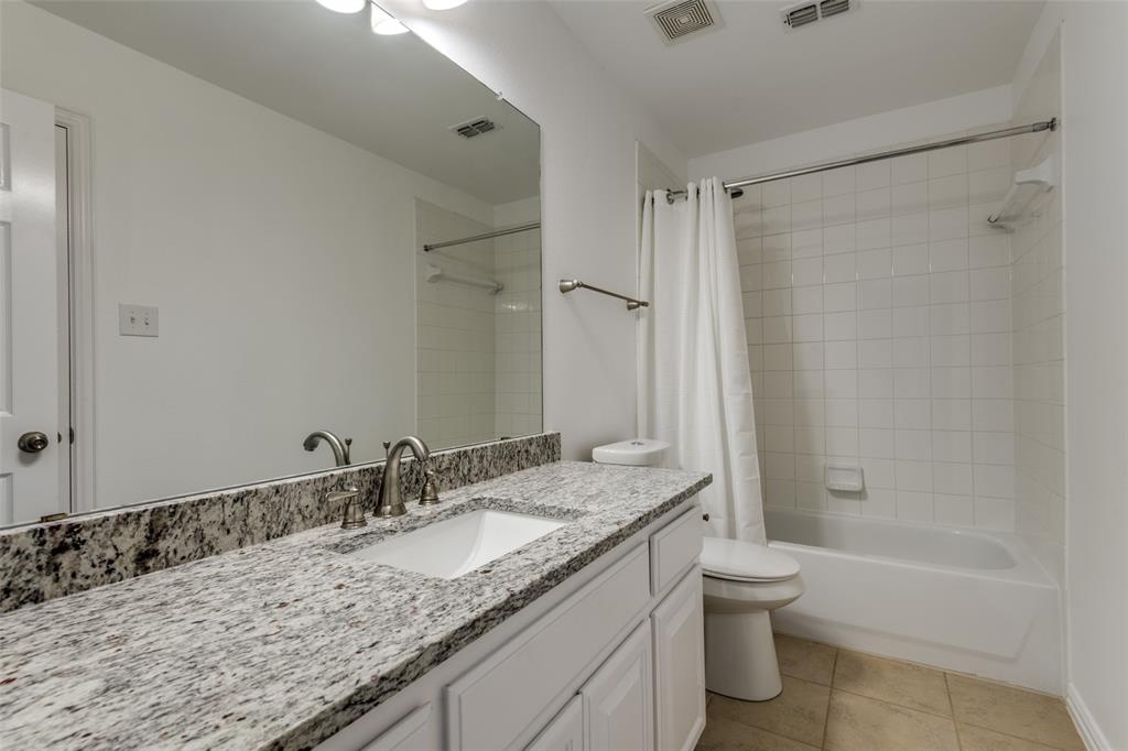 1818 Port Isabel Drive Allen, TX 75013 - Photo 23 of 38 a bathroom with a granite countertop sink a toilet and shower
