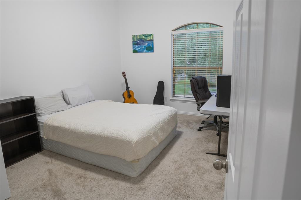 1818 Port Isabel Drive Allen, TX 75013 - Photo 25 of 38 a bed room with a bed a computer and a printer on a dresser next to a window