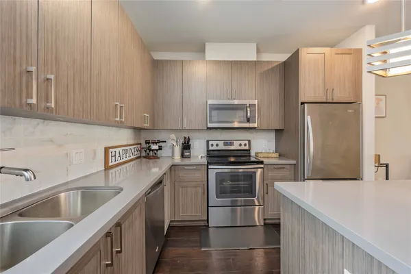 a kitchen with stainless steel appliances granite countertop a refrigerator sink and stove