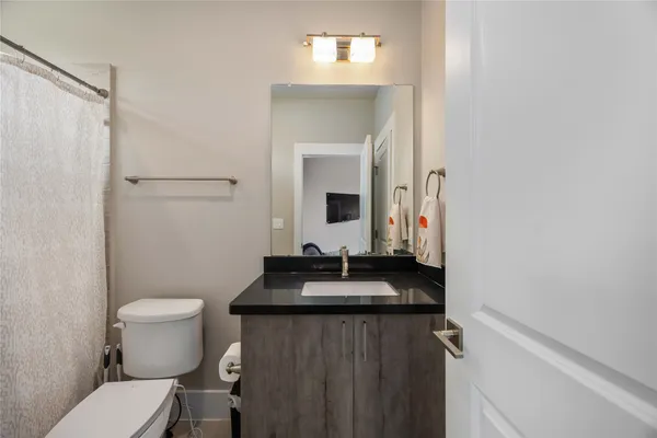 a bathroom with a sink toilet and mirror