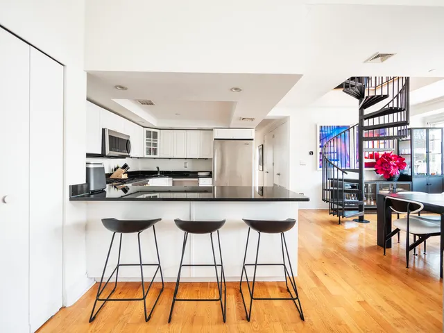 a living room with stainless steel appliances kitchen island granite countertop furniture and a flat screen tv