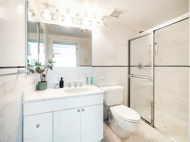 a bathroom with a sink toilet vanity and shower