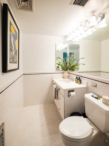 a white toilet sitting next to a bathroom sink