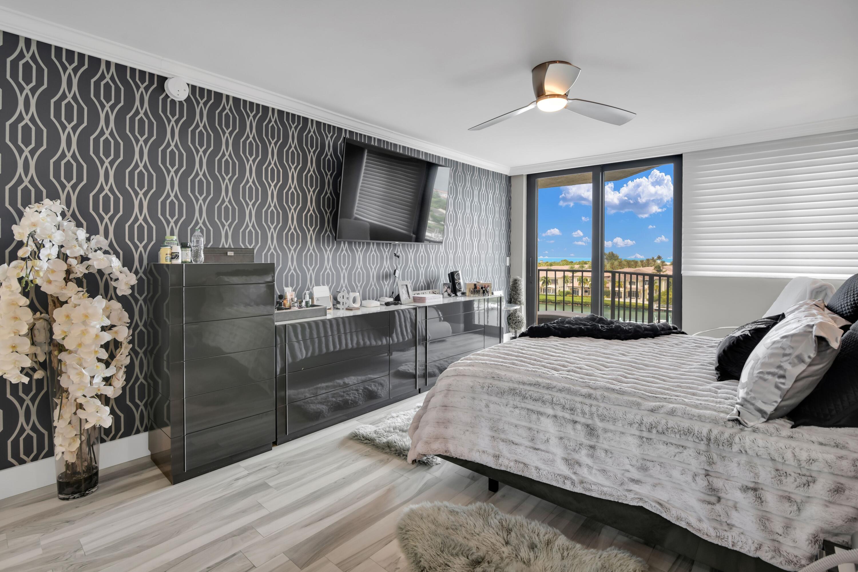 899 Jeffery Street, Unit 714 Boca Raton, FL 33487 - Photo 15 of 51 a bedroom with a large bed and a chandelier