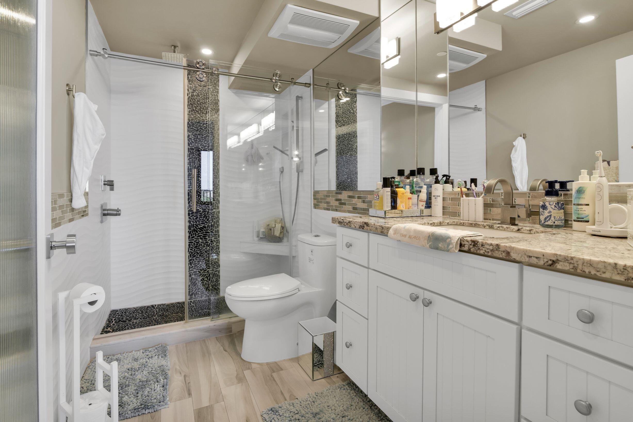 899 Jeffery Street, Unit 714 Boca Raton, FL 33487 - Photo 17 of 51 a bathroom with a double vanity sink toilet and shower