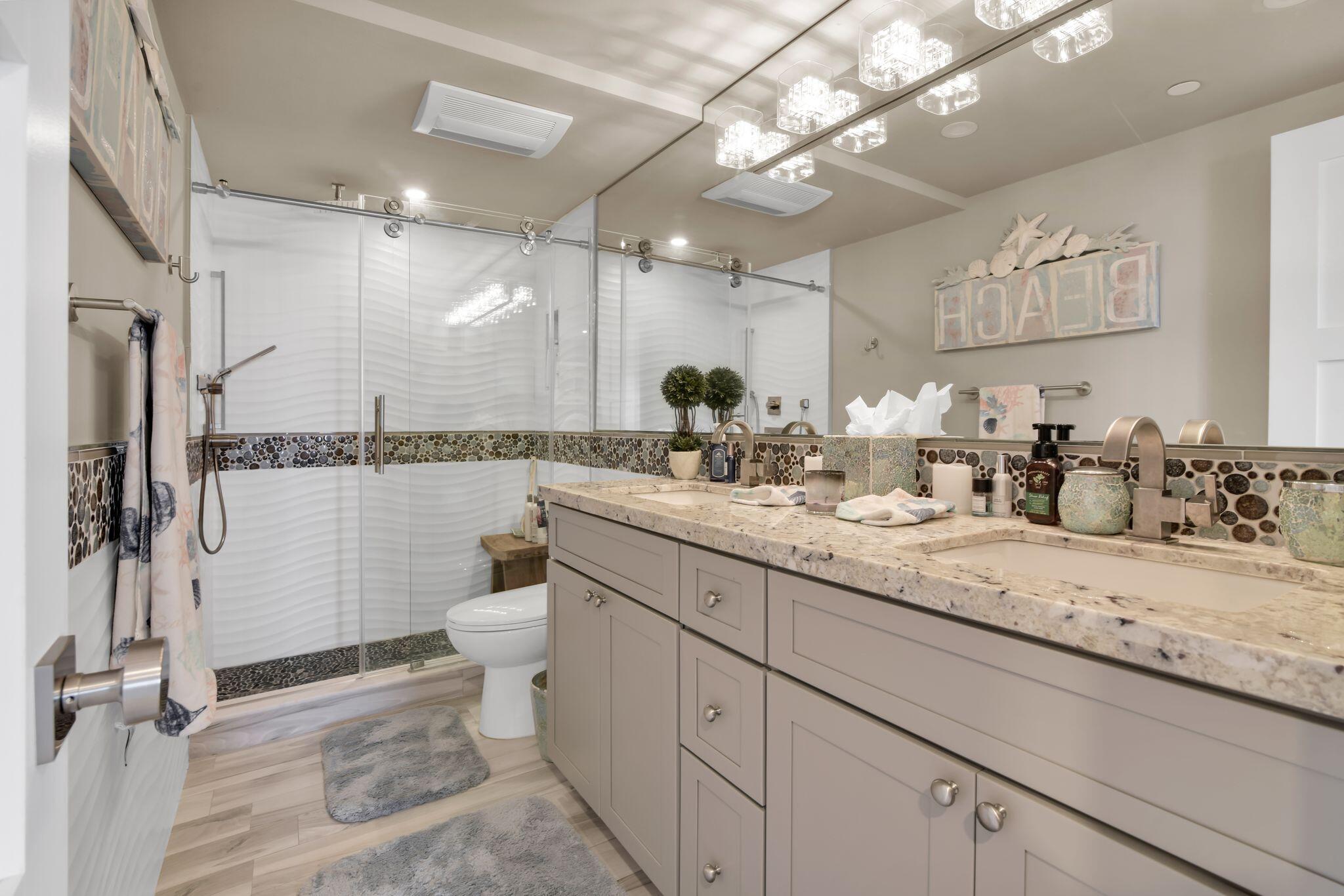 899 Jeffery Street, Unit 714 Boca Raton, FL 33487 - Photo 21 of 51 a bathroom with a double vanity sink toilet and a mirror