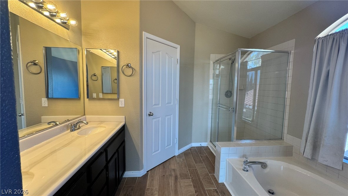 9716 Ridge Creek Place Las Vegas, NV 89134 - Photo 23 of 28 This primary bathroom offers a spacious double vanity, a sleek shower, and a relaxing soaking tub.