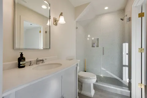a bathroom with a sink a toilet and shower