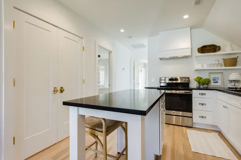 a kitchen with stainless steel appliances granite countertop a sink a stove and a refrigerator