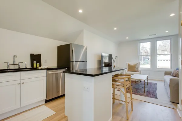 a kitchen with stainless steel appliances granite countertop a sink and a refrigerator