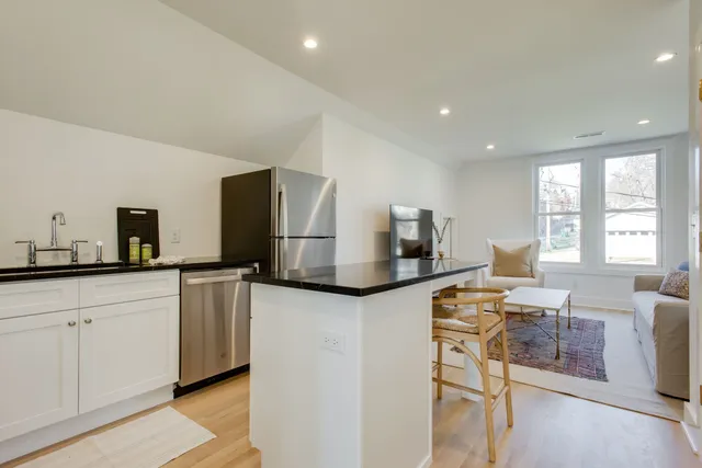 a kitchen with stainless steel appliances granite countertop a sink and a refrigerator
