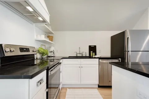 a kitchen with granite countertop cabinets and steel stainless steel appliances