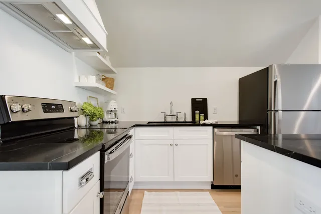 a kitchen with granite countertop cabinets and steel stainless steel appliances