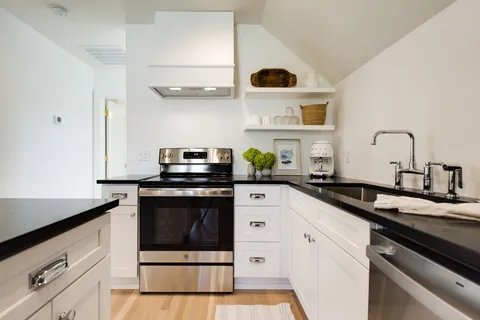 a kitchen with a sink a stove and cabinets
