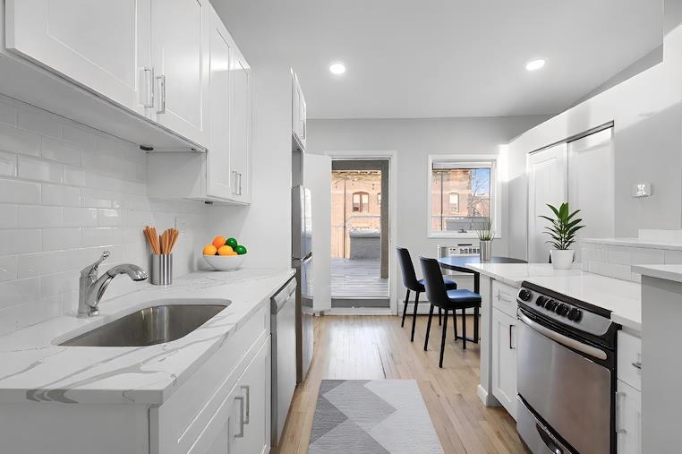431 7th Street, Unit 2B Union City, NJ 07087 - Photo 4 of 16 a kitchen with granite countertop a sink a counter space appliances and cabinets