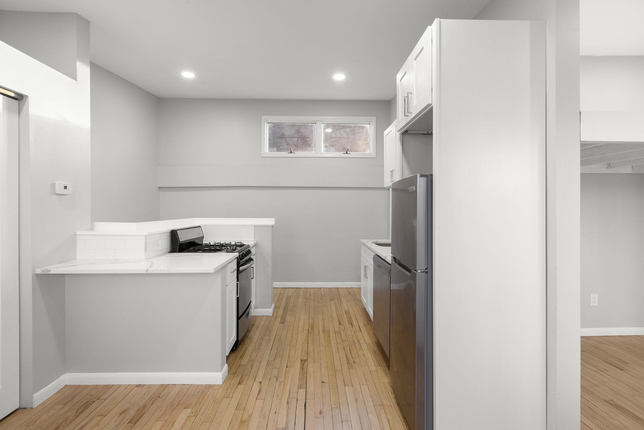 431 7th Street, Unit 2B Union City, NJ 07087 - Photo 5 of 16 a kitchen with a sink a refrigerator freezer and a stove
