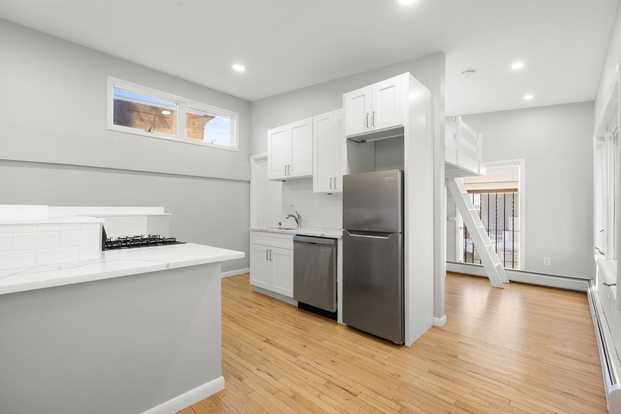 431 7th Street, Unit 2B Union City, NJ 07087 - Photo 8 of 16 a kitchen with a refrigerator sink and wooden floor