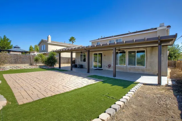 a view of a house with a yard and sitting area