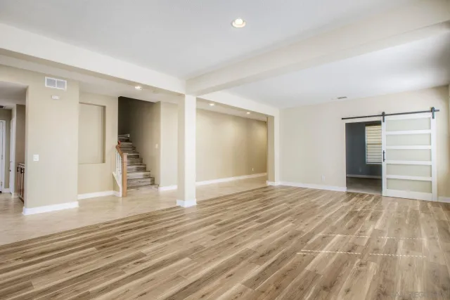 a view of empty room with wooden floor