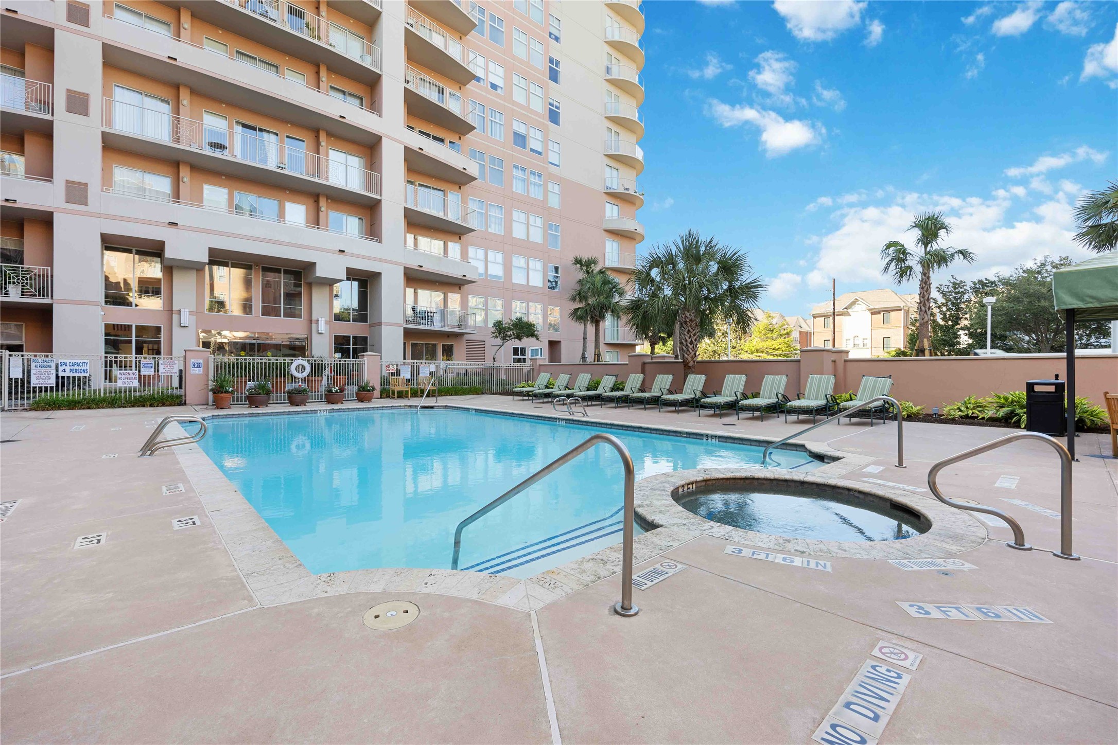 3505 Sage Road, Unit 1508 Houston, TX 77056 - Photo 13 of 23 Enjoy the resort-style enclosed community pool and integrated hot tub, framed by comfortable lounge chairs for excellent weekend relaxation and swimming.