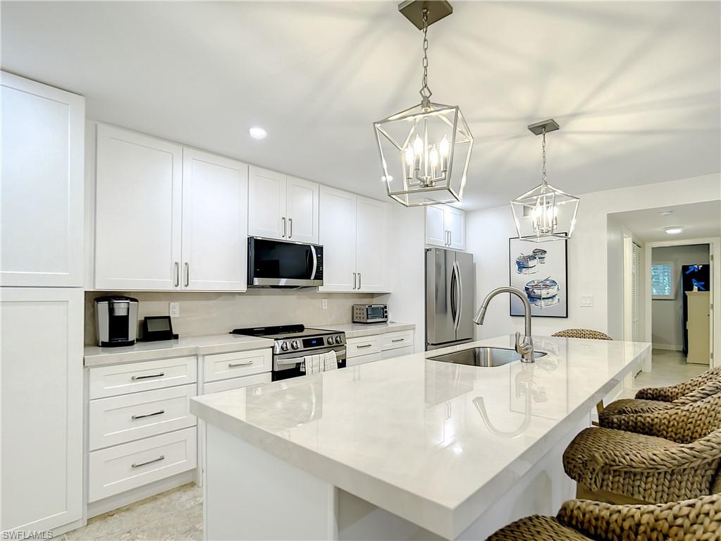 a kitchen with stainless steel appliances kitchen island granite countertop a sink a stove and a microwave