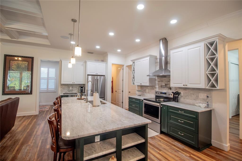 14056 Hydrangea Avenue Port Charlotte, FL 33953 - Photo 14 of 73 a kitchen with stainless steel appliances granite countertop a stove top oven a sink dishwasher a dining table and chairs with wooden floor