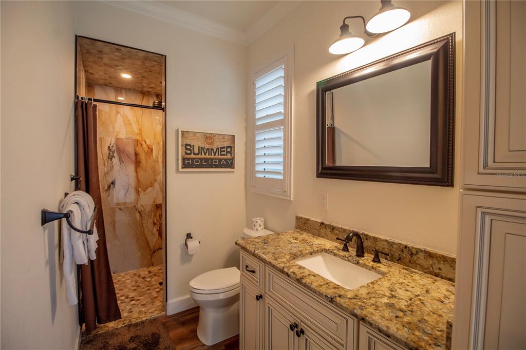 14056 Hydrangea Avenue Port Charlotte, FL 33953 - Photo 21 of 73 a bathroom with a granite countertop sink toilet and shower
