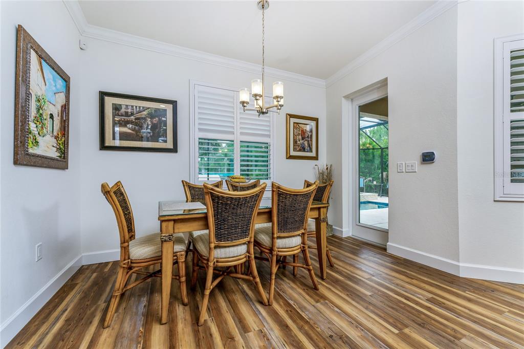 14056 Hydrangea Avenue Port Charlotte, FL 33953 - Photo 55 of 73 a dining room with furniture a chandelier and wooden floor
