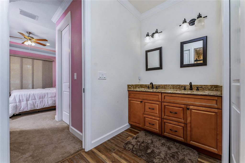 14056 Hydrangea Avenue Port Charlotte, FL 33953 - Photo 60 of 73 a spacious bathroom with a granite countertop sink and a mirror