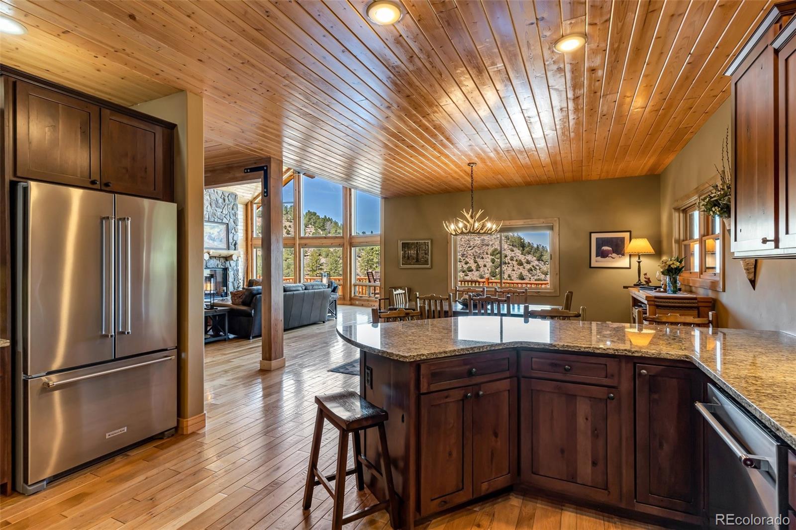 400 Ridge Road Westcliffe, CO 81252 - Photo 11 of 37 a kitchen with stainless steel appliances granite countertop a refrigerator a sink dishwasher a stove and white countertops with wooden floor
