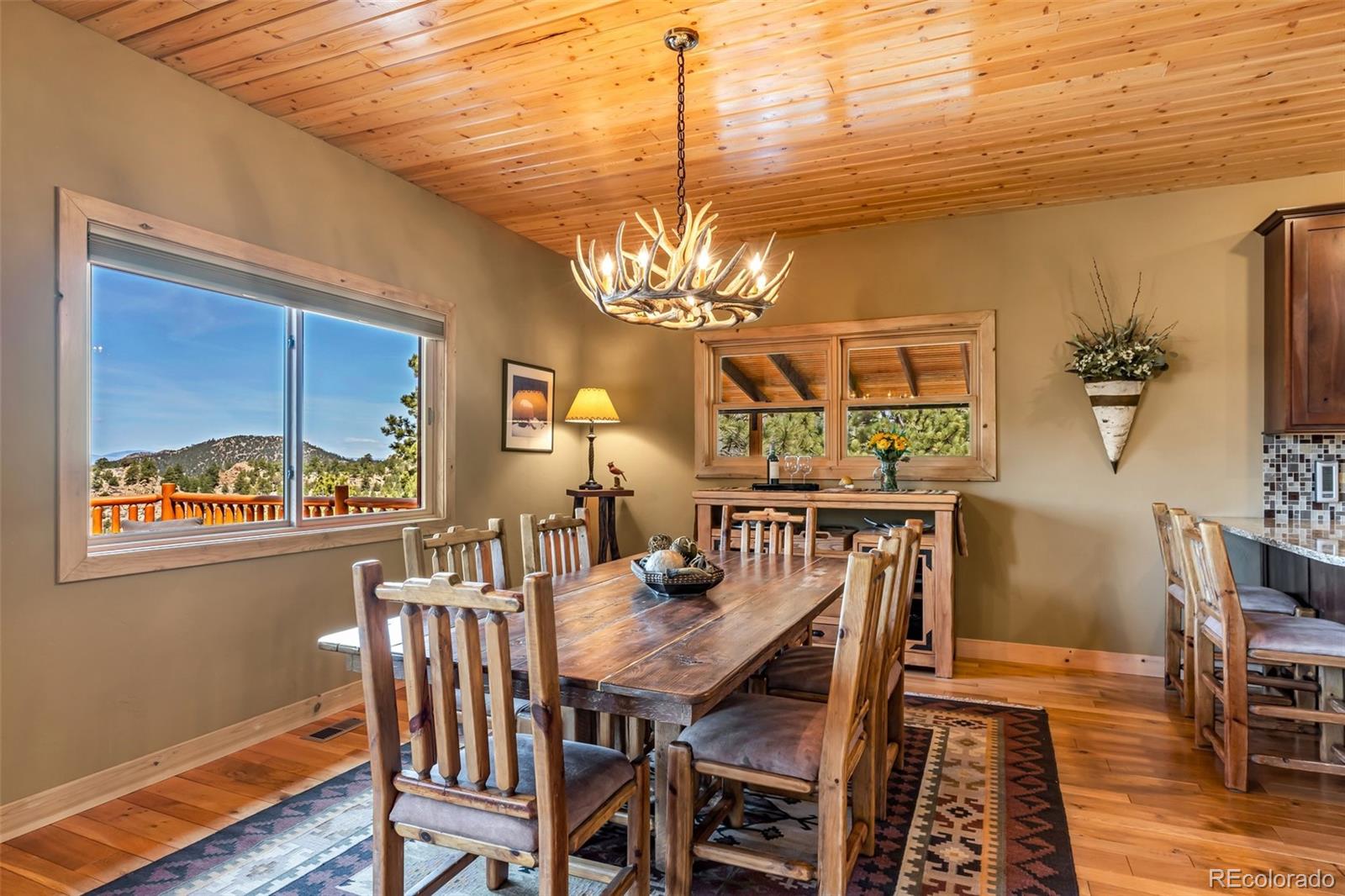 400 Ridge Road Westcliffe, CO 81252 - Photo 8 of 37 a view of a dining room with furniture a chandelier and wooden floor