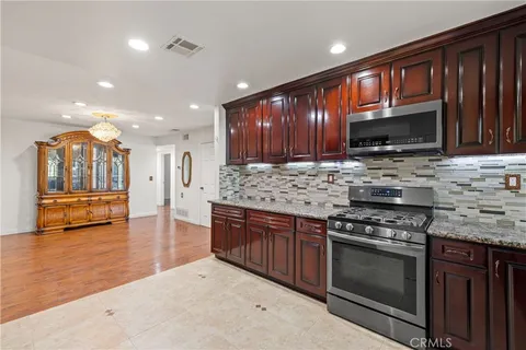 a view of a hallway with entryway wooden floor windows and chandelier