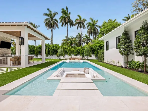 a view of a patio with table and chairs potted plants and palm tree