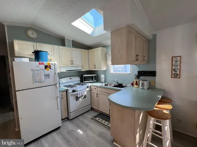 a kitchen with sink a refrigerator and white cabinets