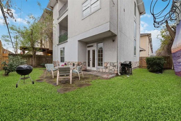 a view of a chair and table in backyard of the house