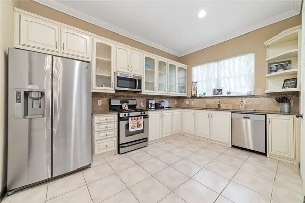 a kitchen with stainless steel appliances a refrigerator sink and microwave
