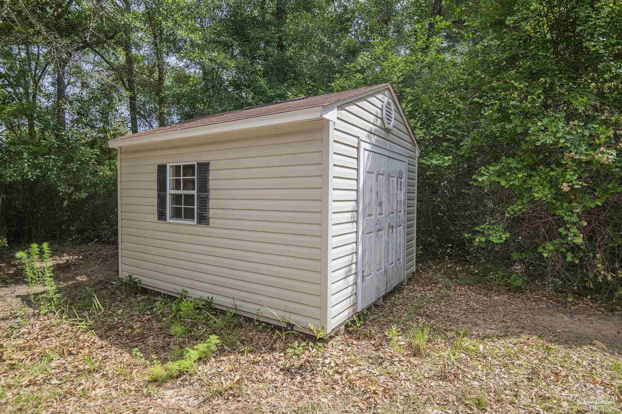 1210 Goldenrod Road Cantonment, FL 32533 - Photo 37 of 50 a view of a small house with a yard