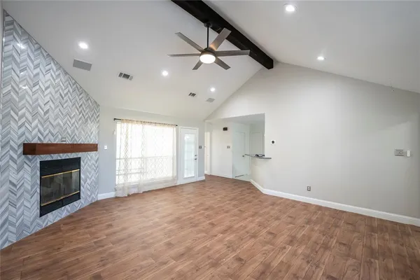 an empty room with windows and fireplace
